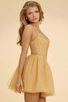 Ozdobiona gorsetowa mini sukienka z tiulową spódnicą w kolorze złotym
