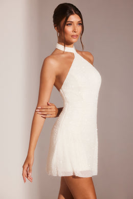 Biała sukienka mini o linii A ze zdobionym asymetrycznym dekoltem