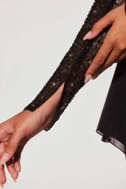 Mini-robe ornée à manches longues et ourlet incliné en noir