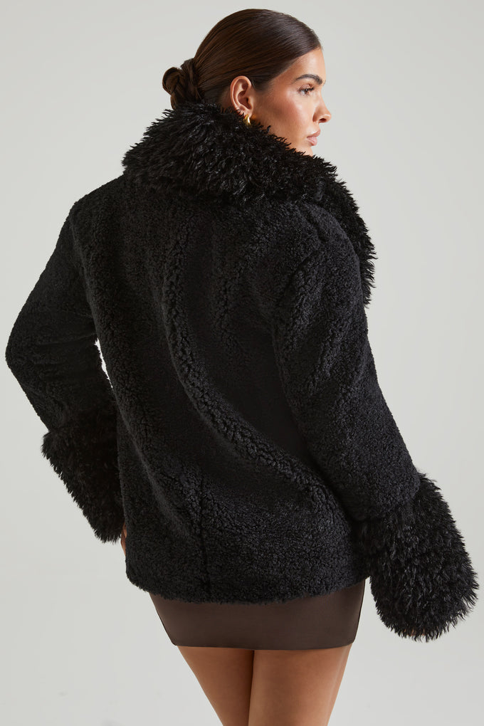 Manteau en peau lainée avec grandes poches avant en noir