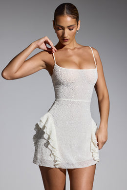 Biała sukienka mini z ozdobną falbanką