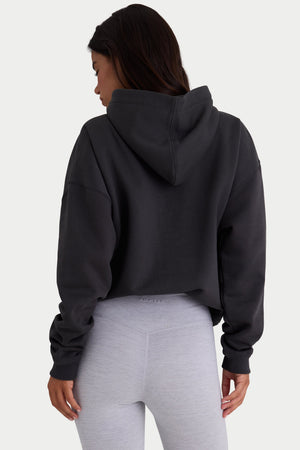 Bo+Tee model Kiele wearing the Varsity Hoodie in Black Cotton fabric perfect for casual outings
