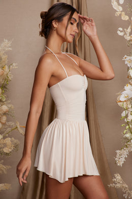 Asymetryczna sukienka mini z dekoltem typu halter w kolorze kremowym