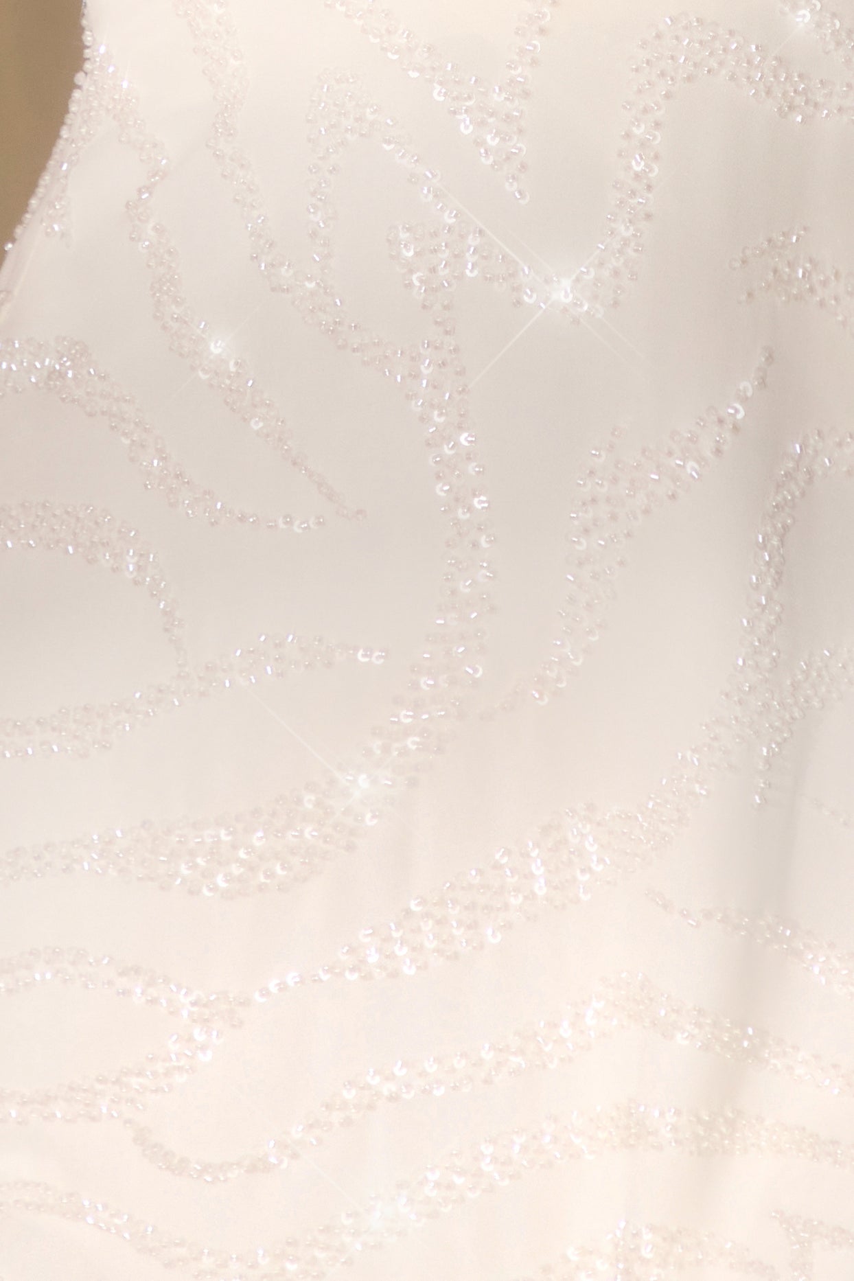 Kopertowa mini sukienka bez rękawów w kolorze złamanej bieli