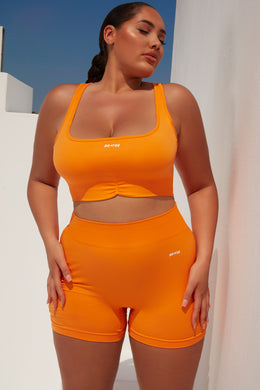 Biustonosz sportowy z promienistymi marszczeniami w kolorze pomarańczowym